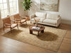 Load image into Gallery viewer, A large beige and brown traditional-style area rug styled in a modern living room with a cream sofa, two wooden armchairs, a round wooden coffee table, and a potted plant.