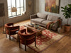 Load image into Gallery viewer, A styled living room scene featuring a beige fabric sofa, two rust-brown velvet armchairs, a wooden coffee table, a large red and beige patterned area rug, a floor lamp, and a potted plant against a textured plaster wall.