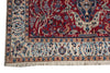 Load image into Gallery viewer, A close-up of an ornate patterned rug corner showing a deep red field with cream, blue, and beige floral and bird motifs, plus a decorative border and fringe.