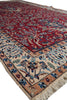 Load image into Gallery viewer, A traditional oriental area rug with a deep red field, beige border, and blue floral motifs, shown on a white background.