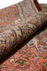 Load image into Gallery viewer, A close-up of a rolled area rug showing its intricate traditional pattern in warm tones of terracotta, beige, and brown.