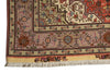 Load image into Gallery viewer, A close-up of an ornate patterned rug corner showing cream, pink, rust red, and brown floral motifs with a fringed edge on a white background.