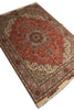 Load image into Gallery viewer, A traditional Persian-style area rug with a red central field, beige and brown borders, and cream fringe, shown on a plain white background.