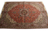Load image into Gallery viewer, A traditional Persian-style area rug with a complex geometric and floral pattern, featuring a dominant red central field, beige and brown borders, and small blue accents.