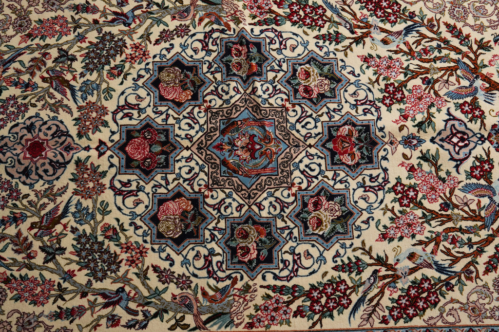 An ornate traditional Persian-style area rug with a cream background, featuring a central medallion and surrounding floral motifs in red, blue, green, and brown.