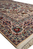 Load image into Gallery viewer, A close-up of a traditional oriental rug with a beige background and intricate floral motifs in red, blue, green, and brown, featuring a fringed edge.