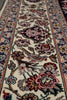 Load image into Gallery viewer, A close-up view of an ornate Persian-style area rug with a cream background, featuring a central bird motif surrounded by detailed floral patterns and a decorative border.
