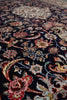 Load image into Gallery viewer, A close-up view of an ornate area rug with a dark navy blue background and intricate floral, paisley, and bird motifs in red, pink, beige, cream, and light blue.
