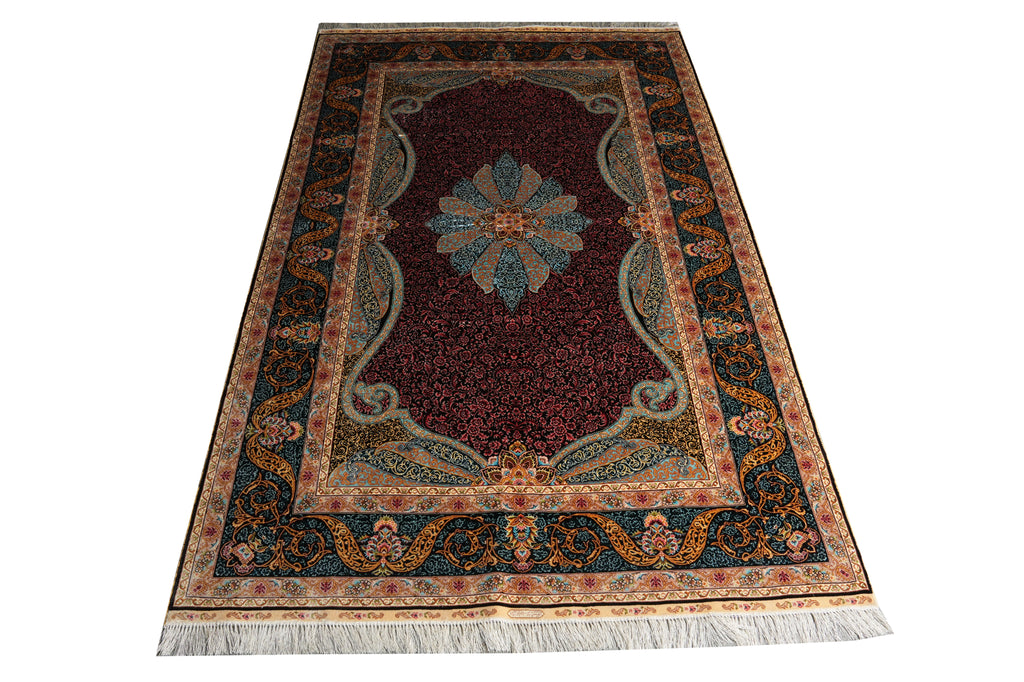 A traditional oriental area rug with a deep red central field, a blue and gold central medallion, and an ornate dark blue border with cream and gold details, finished with white fringe on the bottom.