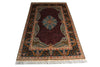 Load image into Gallery viewer, A traditional oriental area rug with a deep red central field, a blue and gold central medallion, and an ornate dark blue border with cream and gold details, finished with white fringe on the bottom.