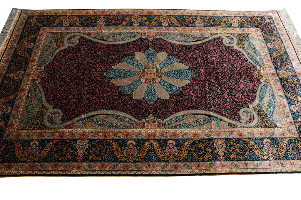 A traditional oriental area rug with a dark red central field, a blue and beige floral medallion, and an ornate patterned border in blue, beige, and gold.