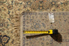 Load image into Gallery viewer, A close-up of a patterned area rug with beige, blue, and brown floral motifs and fringe, shown with a yellow tape measure and a price tag on top.