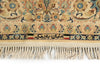 Load image into Gallery viewer, Close-up of a patterned rug with cream, beige, blue, and brown floral motifs, a decorative border, and cream fringe along the bottom edge. Persian text is woven into the border.