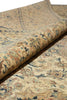 Load image into Gallery viewer, A close-up of a rolled section of a traditional patterned rug showing its beige base with blue, brown, and muted orange floral motifs.