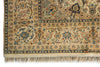 Load image into Gallery viewer, A close-up of an ornate Persian-style area rug showing its intricate floral and vine patterns, cream and beige base color, and fringed edge.