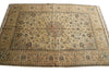 Load image into Gallery viewer, An antique Persian-style area rug with a beige and brown base, decorated with intricate floral motifs in blue, green, and rust red, laid flat on a white background.