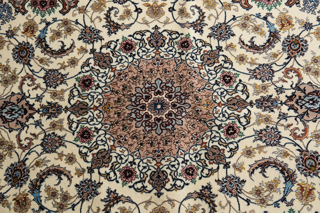 A close-up of an ornate Persian-style area rug featuring a central medallion and intricate floral motifs in beige, brown, blue, and muted red tones.