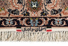 Load image into Gallery viewer, Close-up of a patterned rug with cream fringe, featuring a beige field, a dark navy border with floral motifs, and a central label with Persian text.
