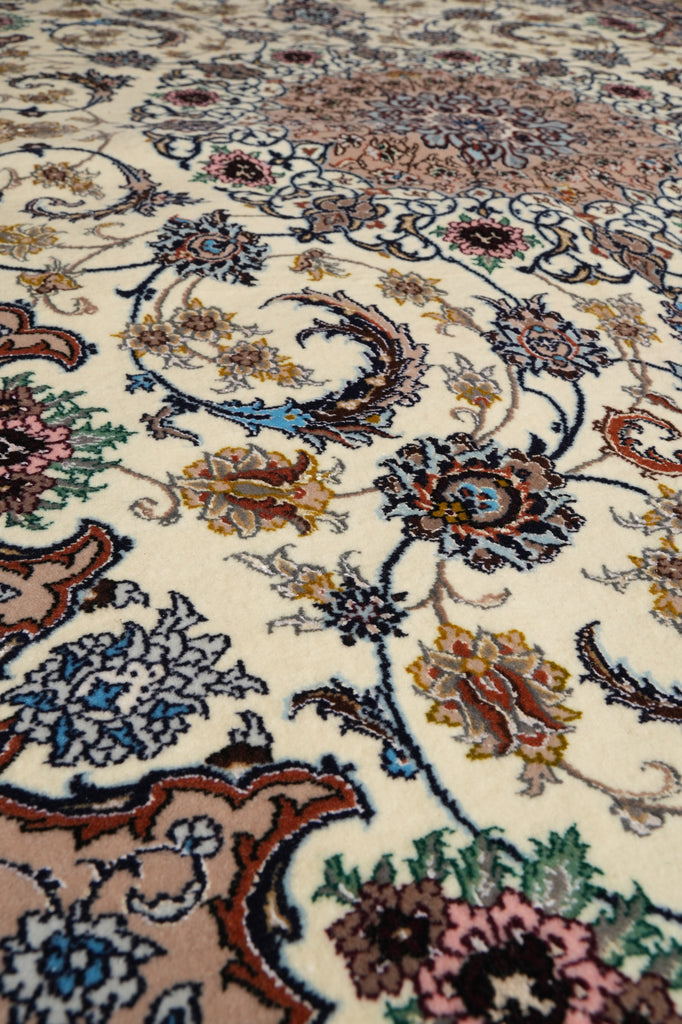 Close-up of an ornate traditional patterned rug with cream background and floral motifs in blue, pink, brown, green, and gold.