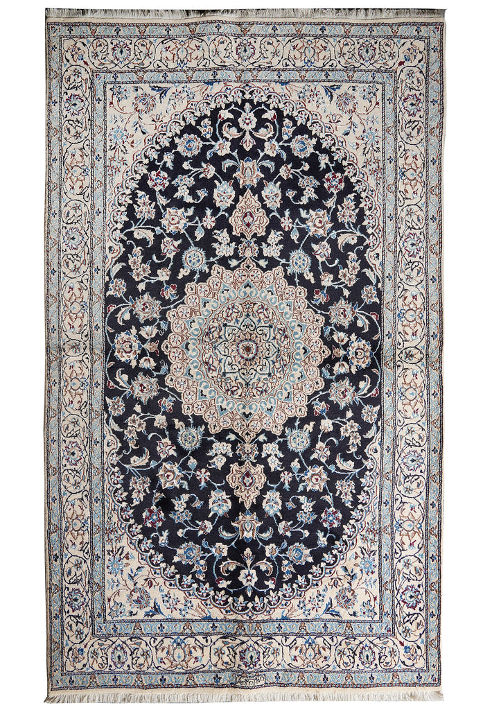 A traditional oriental area rug with an intricate floral pattern, featuring a dark navy blue central field, a large oval medallion, and a detailed cream and beige border.
