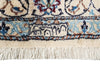 Load image into Gallery viewer, Close-up of an ornate patterned rug corner showing cream, blue, brown, and burgundy woven detailing with fringe along the bottom edge.