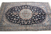 Load image into Gallery viewer, A traditional oriental area rug with a dark navy blue central field, featuring a large oval medallion and intricate floral motifs in beige, light blue, and cream, surrounded by a patterned border.