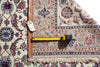Load image into Gallery viewer, An ornate patterned area rug shown with a tape measure and price tag to indicate size and condition. The rug features a traditional floral and medallion design in beige, blue, red, and brown tones with a braided brown border and cream fringe.