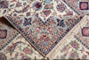 Load image into Gallery viewer, A close-up of a traditional patterned rug with cream, beige, and red floral motifs, featuring a detailed geometric border and fringed edges.