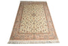 Load image into Gallery viewer, An oriental-style area rug with a cream-colored center, detailed floral motifs, and a patterned border in muted pink, blue, and brown tones, finished with white fringe on the ends.