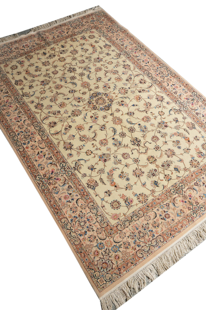 A traditional oriental-style area rug with an intricate floral pattern, featuring a beige center, a dusty pink border, and cream fringe on the ends.