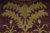 Load image into Gallery viewer, Close-up of a woven rug or textile with a large green leafy botanical motif on a deep purple background, with smaller matching floral details near the bottom.