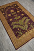 Load image into Gallery viewer, A rectangular area rug with a deep burgundy center and a wide gold border, featuring a large green thistle design in the middle. The rug is shown from an overhead angle on a gray wood-look floor.