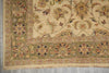 Load image into Gallery viewer, A close-up of an ornate traditional rug corner showing a cream field with floral motifs and a wide olive-green border with multicolored floral details and fringe.