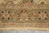 Load image into Gallery viewer, Close-up of a patterned area rug with a central floral medallion and border motifs in muted olive green, beige, rust red, and navy tones, with visible fringe along the bottom edge.