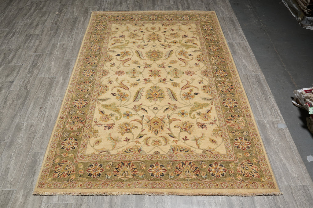A rectangular traditional area rug with an ornate floral and vine pattern, displayed on a gray wood-look floor.