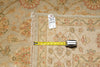 Load image into Gallery viewer, A close-up of a patterned area rug with a white price tag and a yellow tape measure laid across it to show dimensions.