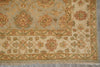 Load image into Gallery viewer, A close-up of an ornate area rug with a traditional floral and medallion pattern. The rug features a warm beige base with intricate motifs in muted green, terracotta red, and soft blue, finished with a fringed edge.