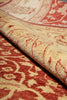Load image into Gallery viewer, A close-up of a folded area rug showing its cream and rust-red patterned pile and woven texture.