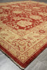 Load image into Gallery viewer, A traditional oriental-style area rug with a warm beige base and a rust red floral pattern, shown laid out on a gray tiled floor.
