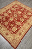 Load image into Gallery viewer, A traditional oriental area rug with a red field and beige floral motifs, laid out on a gray wood-look floor.