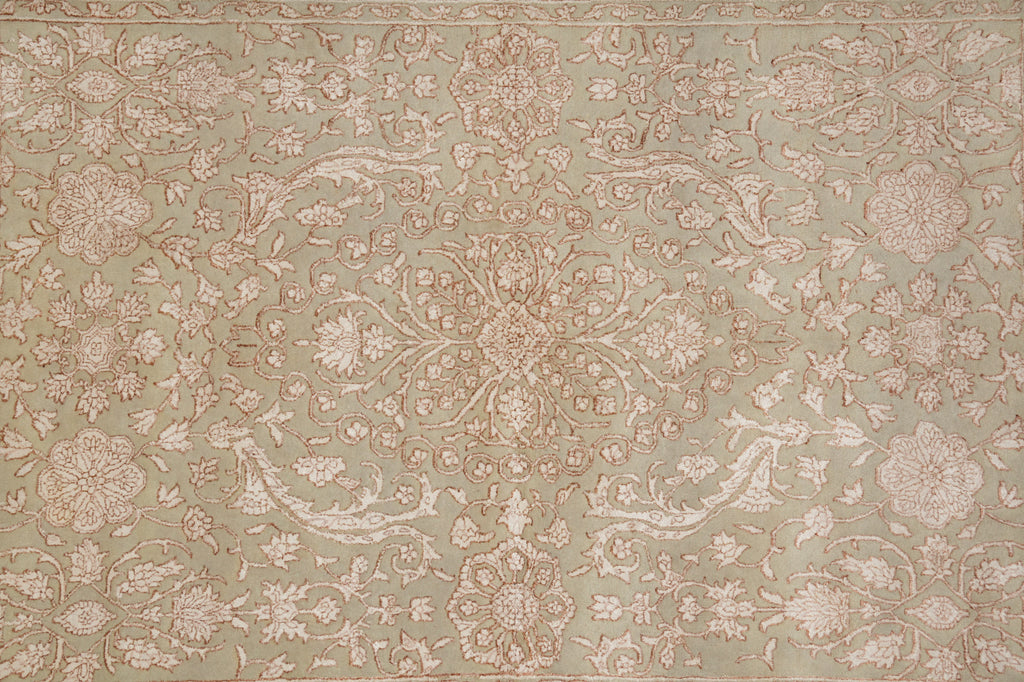 A close-up of an ornate floral patterned fabric or wallpaper in muted sage green with dusty pink and beige motifs.