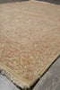 Load image into Gallery viewer, A close-up of a traditional area rug with a beige base and dusty rose floral patterns, laid out on a gray tiled floor.