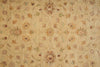 Load image into Gallery viewer, A close-up of a woven rug or textile with a repeating floral and geometric pattern in warm beige, tan, muted green, and brown tones.