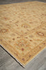 Load image into Gallery viewer, A traditional area rug with a warm beige and golden-yellow base, featuring faded floral and geometric motifs in muted brown, green, and rust tones, shown laid out on a gray wood floor.