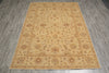 Load image into Gallery viewer, A rectangular area rug with an intricate traditional floral pattern in beige, tan, and muted brown tones, laid out on a gray wood-look floor.