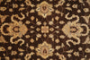Load image into Gallery viewer, A close-up of a dark brown rug with an ornate beige and cream floral pattern.