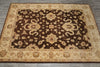 Load image into Gallery viewer, A rectangular area rug with an ornate traditional floral pattern, featuring a dark brown center field and a beige border, laid out on a gray wood floor.