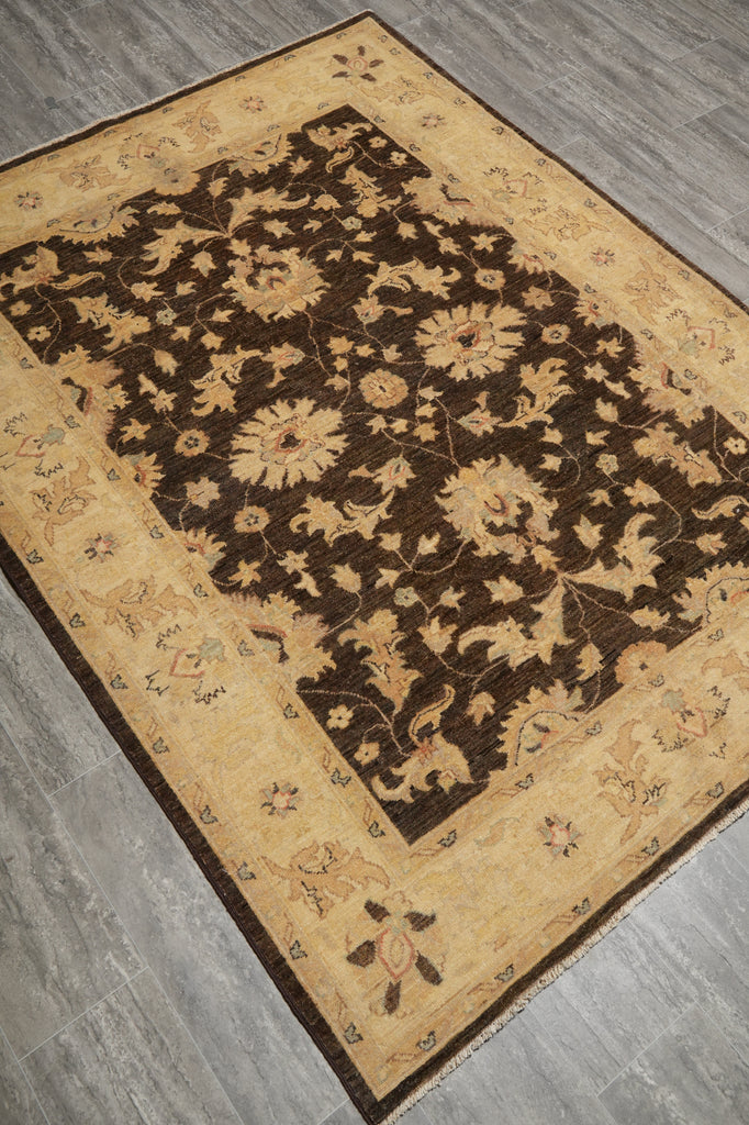 A rectangular area rug with a dark brown central field and a beige border, laid out on a gray wood-look floor.