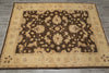 Load image into Gallery viewer, A rectangular area rug with an ornate floral and vine pattern, featuring a dark brown center field surrounded by a wide beige border, laid flat on a gray tiled floor.