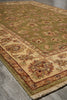 Load image into Gallery viewer, A traditional oriental area rug with an olive green field, beige border, and floral motifs, shown laid out on a gray stone floor.